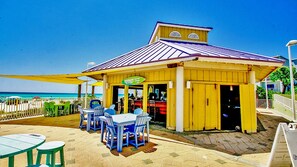 A beachside restaurant with outdoor seating and a view of the ocean. - Boardwalk Resort 511 (Panama City Beach)