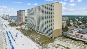 A large hotel with multiple floors, a beachside location, and a visible swimming pool. - Emerald Beach 1525 (Panama City Beach)