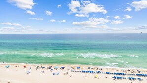 A beach with clear turquoise water and a sandy shore. - Emerald Beach 1525 (Panama City Beach)