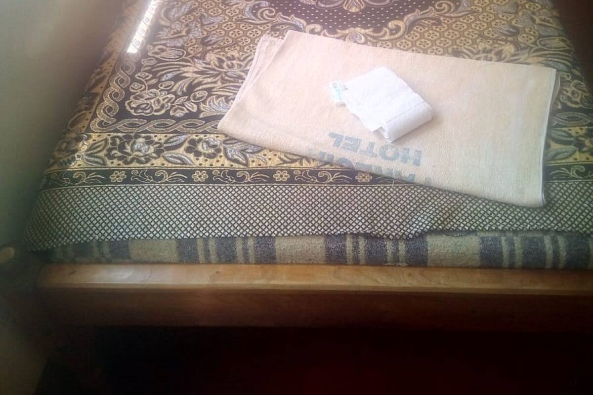 A room with a patterned sofa, a small wooden table, and a window with curtains.