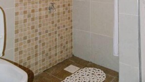 A bathroom with a shower, tiled walls, a toilet, and a sink. - VAKANA STUDIO'S 202-One space, everything at the right place (Nairobi)