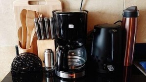 A kitchen counter with a coffee maker, a thermos, and a knife block. - VAKANA STUDIO'S 202-One space, everything at the right place (Nairobi)