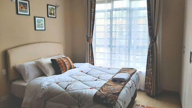 A bedroom with a bed, a headboard, a window with curtains, and three framed pictures on the wall. - VAKANA STUDIO'S 202-One space, everything at the right place (Nairobi)