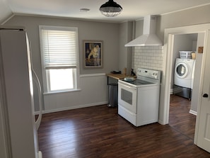 Modern kitchen with oven, stovetop, and laundry area.