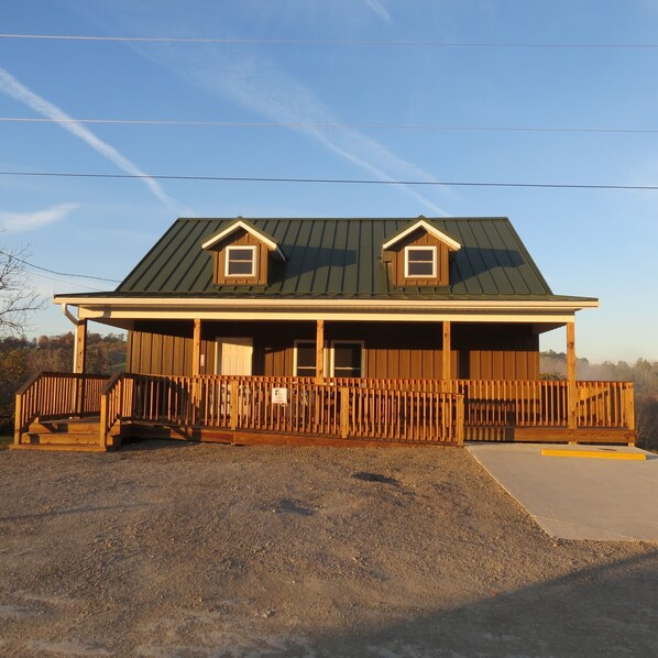 A two-story wooden building with a porch and a small ramp leading to the entrance.