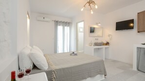 A bedroom with a bed, bedside table, and a TV mounted on the wall. - Casa Verde di Naxos (Naxos)