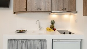 A modern kitchen with wooden cabinets, a white countertop, and a built-in refrigerator. - Casa Verde di Naxos (Naxos)