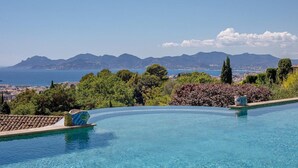 Une piscine avec vue sur la mer et les montagnes.