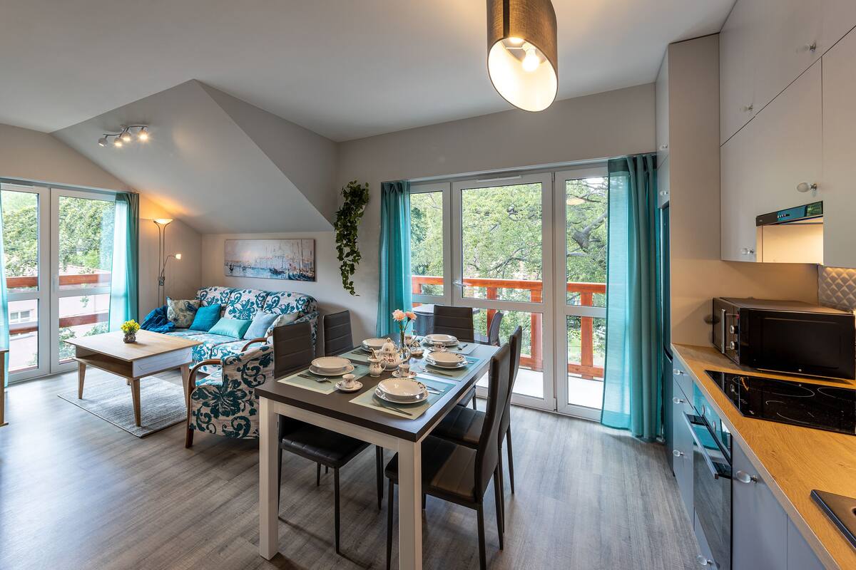 Ein modernes Wohnzimmer mit Essbereich, einer Couch und einer Küche.