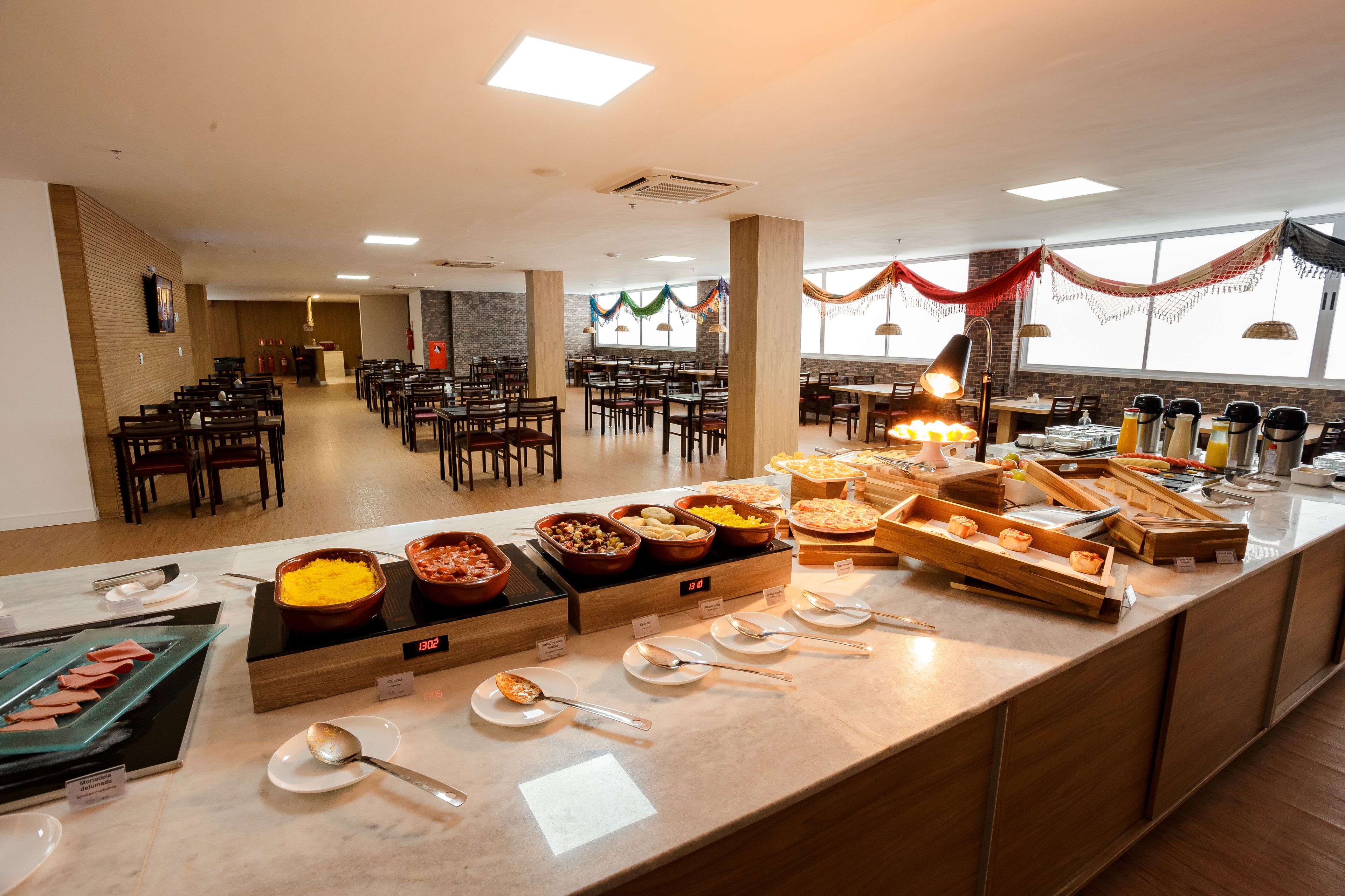 A buffet setup with various food items and serving utensils.
