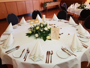 A round table set for a formal event with white tablecloths, gold napkins, and a floral centerpiece. - Landgasthaus Echtzer Hof (Dueren)