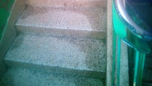 Eine Treppe mit Geländer auf der rechten Seite, die zu einer oberen Etage führt.