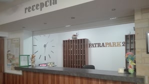 A reception desk with a clock, a wooden cabinet, and a wall sign reading "FATRAPARK2".