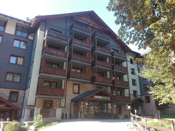 A multi-story hotel with balconies, a stone facade, and a sign reading "FATRA PARK 2".