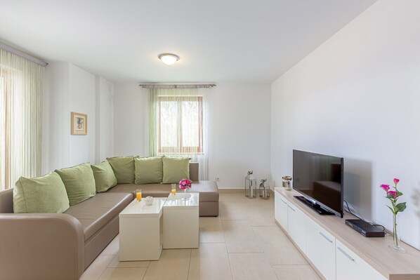 A modern living room with a sofa, coffee table, and TV.
