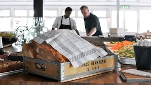 A bakery display with bread and a contact label.