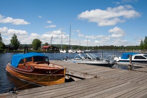 A wooden dock with several boats moored at the pier. - Idas Brygga Skepparehus (Karlsborg)