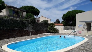 A swimming pool with stone tiles, surrounded by a brick wall and a metal fence. - T3, 60 m2, small building with swimming pool, 1st floor, separate entrance (Collioure)