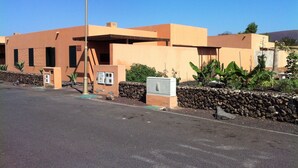 A modern building with a flat roof, a street lamp, and a stone wall. - RELAX AND TRAQUILADAD pair all kinds of families with or without children  (corralejo)