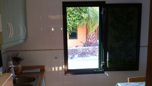 A kitchen with a window, a sink, and a table. - RELAX AND TRAQUILADAD pair all kinds of families with or without children  (corralejo)