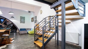 A modern interior with a staircase, a dining area, and a sofa. - Dream Aparts - Lofty Scheiblera (Lodz)