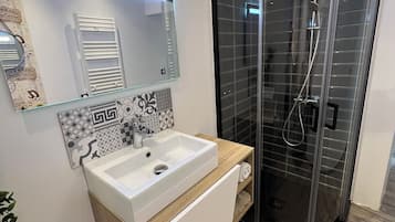 Een douche, handdoeken, zeep, toiletpapier