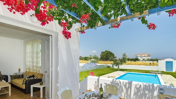 A terrace with a pool, dining area, and a view of the sea. - White House Villas (Rhodes)