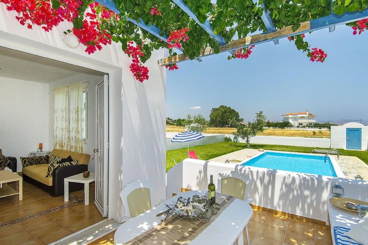Eine Terrasse mit Pool, Essbereich und Meerblick.