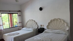 Two single beds with scalloped headboards, a nightstand, and a window with curtains. - Hotel Albatros (Puerto Escondido)