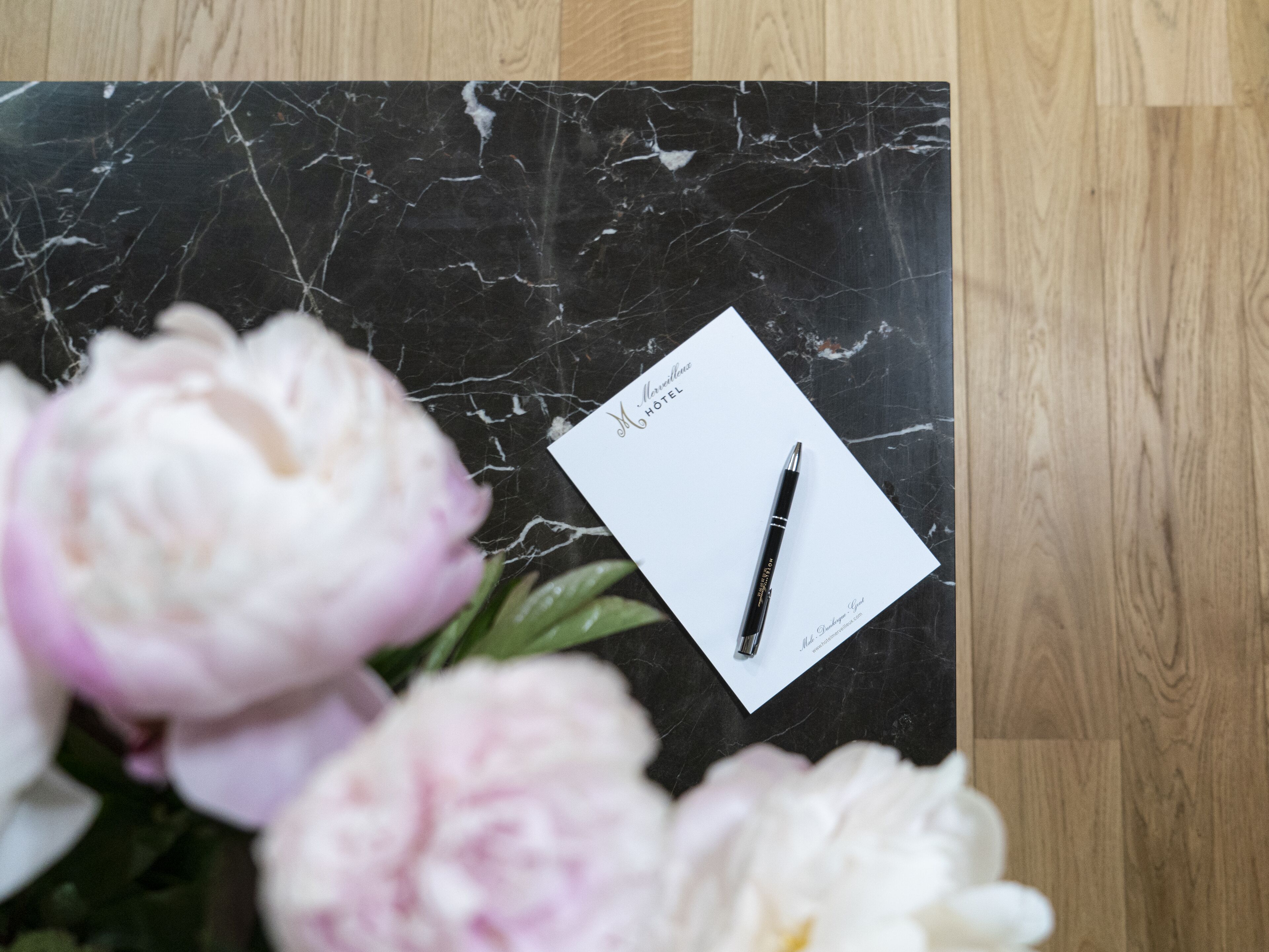 A black marble surface with a white card labeled "M. Williams Hotel" and a pen.