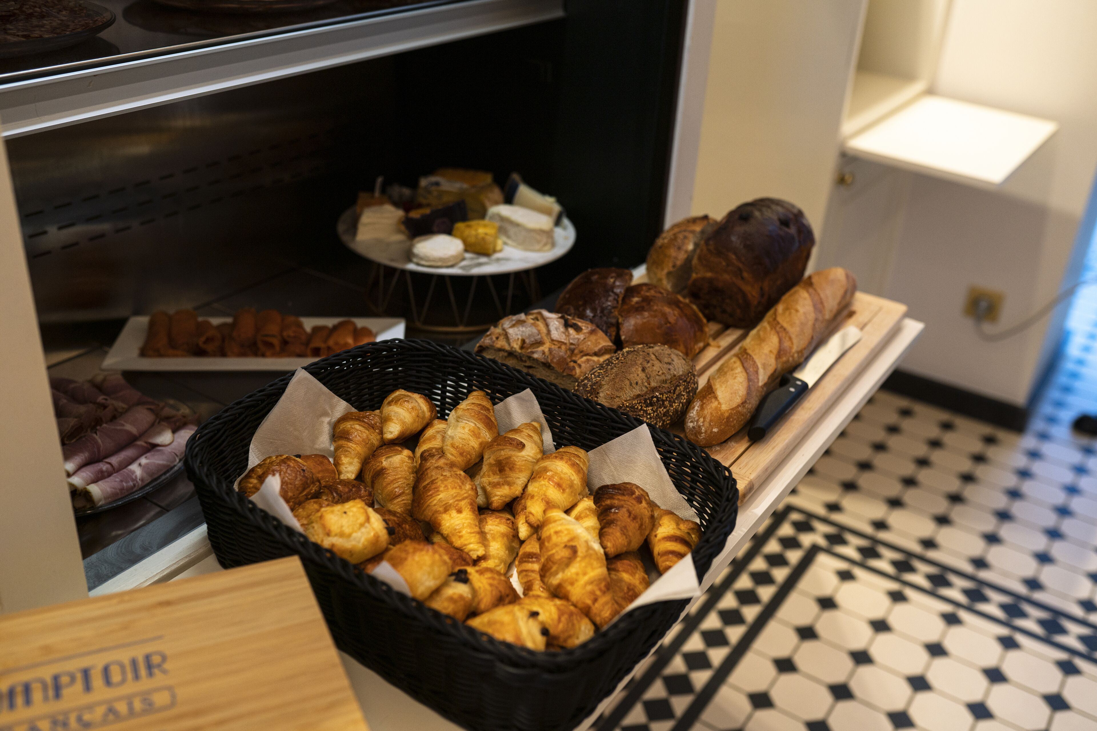 A bakery display with various baked goods including bread, pastries, and rolls.