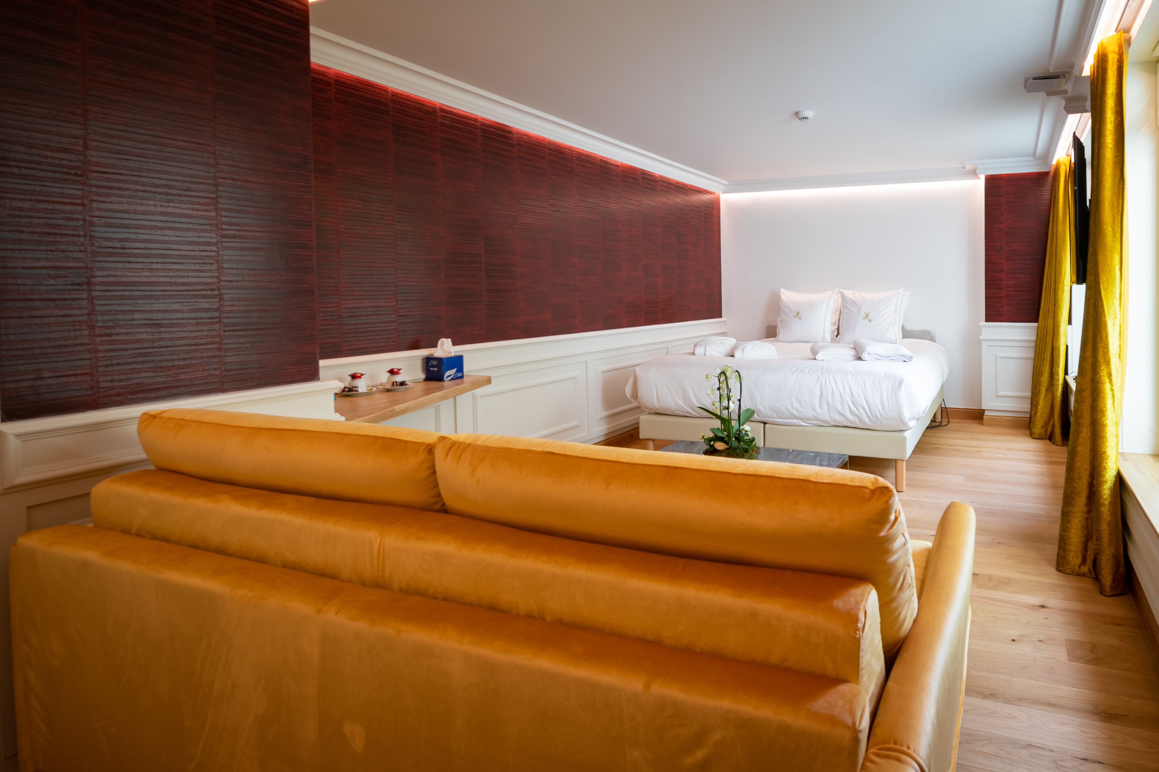 Une chambre d’hôtel moderne avec un grand lit, un canapé et une petite table équipée de tout le nécessaire.