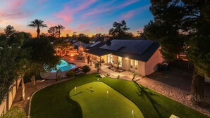 Une propriété résidentielle dotée d’une piscine, d’un patio et d’une pelouse bien entretenue.