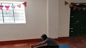 A yoga class in a room with large windows and red walls. - vrinda wasi 108 (Lamay)