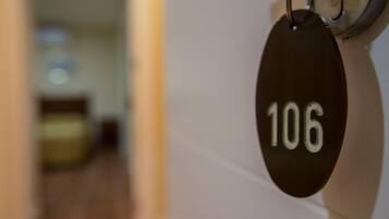 Une vue rapprochée d’une plaque noire portant le numéro de chambre 106, fixée à un mur.