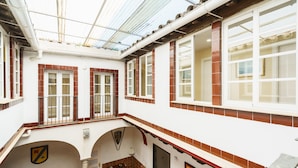 A multi-level building with a glass ceiling, red-tiled walls, and multiple windows. - Hotel Carlos V by Viverestays (Jerez de la Frontera)