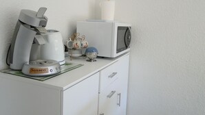 A kitchenette with a coffee maker, microwave, and tea kettle. - Comfortable studio with view of pond and Chateau (Chauffailles)