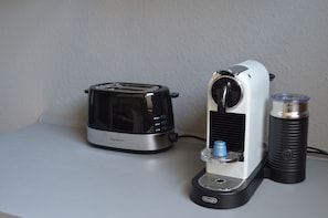 Une cuisine avec un grille-pain et une machine à café posés sur un plan de travail.