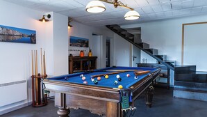 Un biliardo con le bocce, una scala e un dipinto con una vista sulla città.