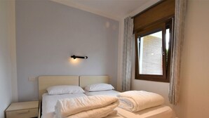 A bedroom with a bed, bedside tables, and a window with curtains. - Lovely apartment in villa for 5 guests with WIFI, TV, terrace and pets allowed (Crone)