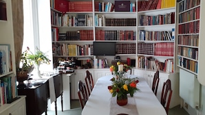 A library with bookshelves, a dining table with chairs, and a television. - Garfits lodge (Boston)