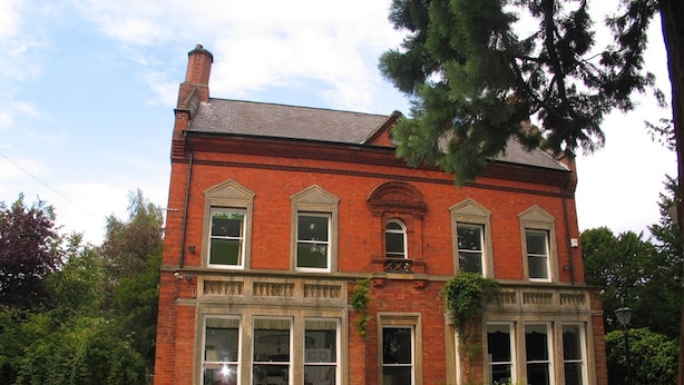 A two-story brick building with large windows and a chimney. - Garfits lodge (Boston)