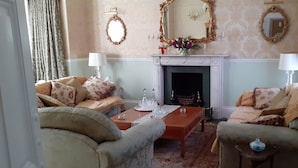 A traditional sitting room with two sofas, a fireplace, and a mirror on the wall. - Garfits lodge (Boston)