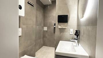 A modern bathroom with a toilet, sink, and shower.