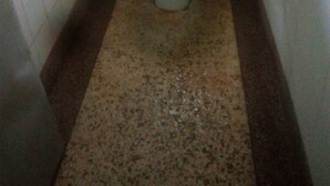 A small bathroom with a toilet, a sink, and a toilet paper holder on the wall. - Twiga Guest House (Thika)
