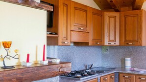 A kitchen with wooden cabinets, a granite countertop, and a gas stove.