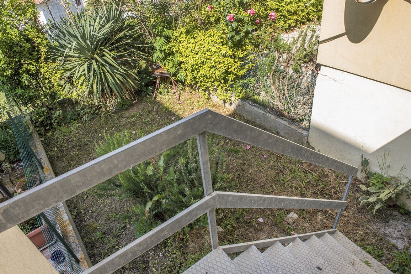A metal staircase with a metal railing leading to a building.