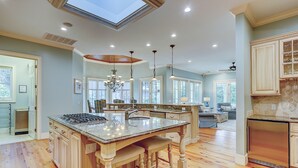 A spacious kitchen with a central island, wooden flooring, and a skylight. - 3rd Row Ocean ~ Five Bedroom Sea Pines Home ~ Private Pool & Spa ~ Sleeps 20 (Hilton Head Island)