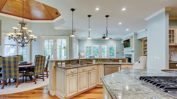 A spacious kitchen with a large island, wooden cabinets, and a dining area with plaid chairs. - 3rd Row Ocean ~ Five Bedroom Sea Pines Home ~ Private Pool & Spa ~ Sleeps 20 (Hilton Head Island)