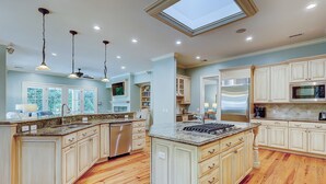 A spacious kitchen with a large island, wooden cabinets, a built-in oven, and a skylight. - 3rd Row Ocean ~ Five Bedroom Sea Pines Home ~ Private Pool & Spa ~ Sleeps 20 (Hilton Head Island)